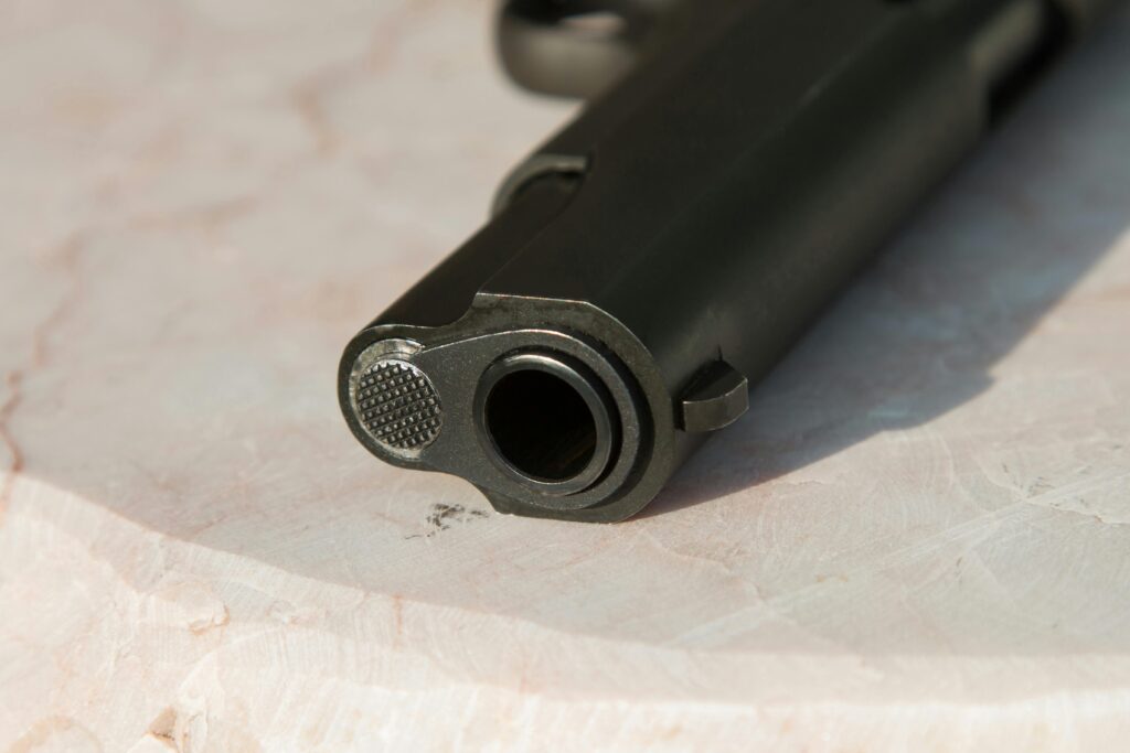 Close-up of a firearm muzzle resting on a light-colored marble surface for firearm safety.